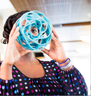Woman looking through blue spiral ball